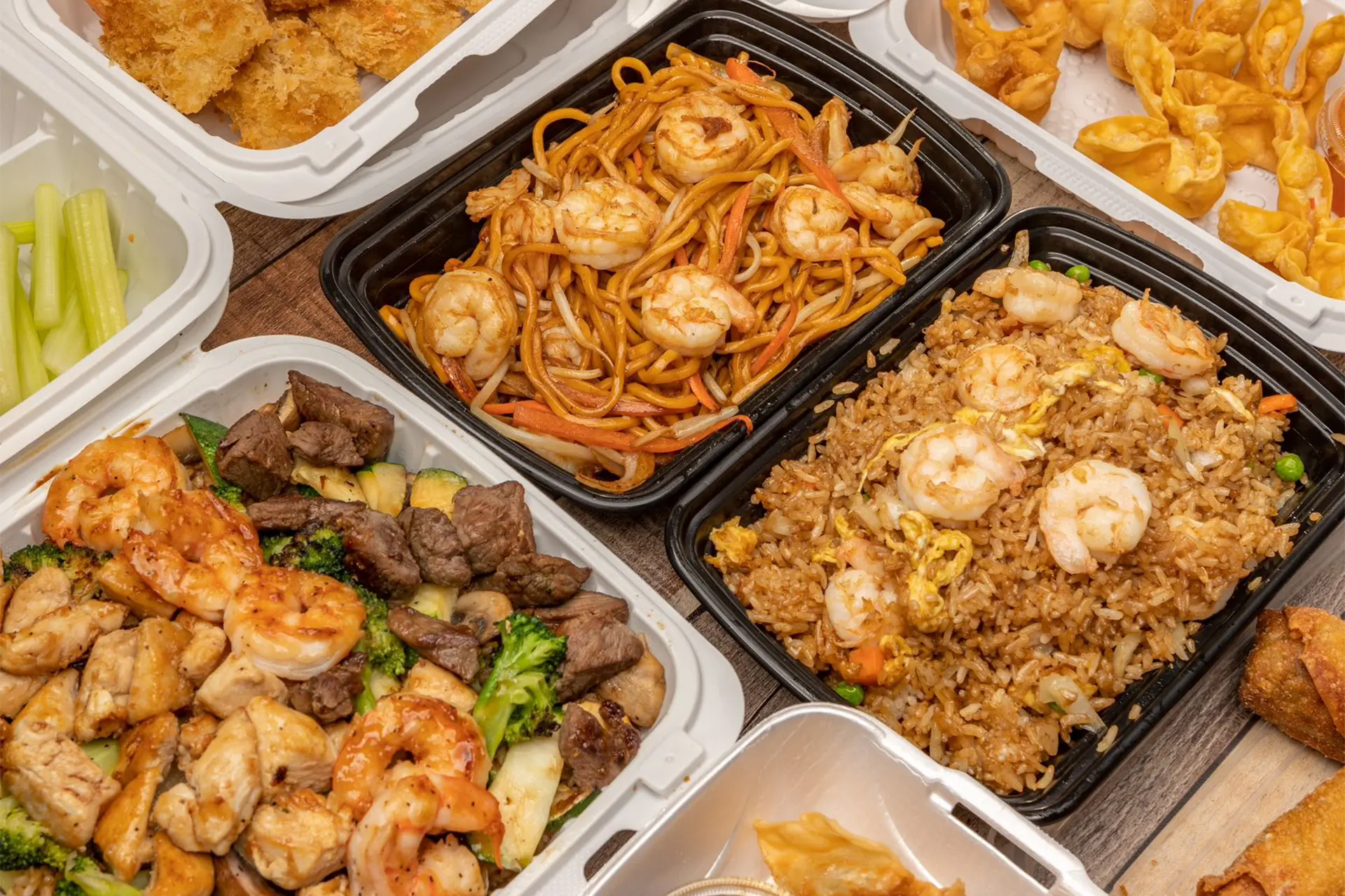 Assorted hibachi and wings takeout spread with shrimp lo mein at Aaron Wings & Hibachi, a Hibachi & Wings Restaurant in Stockbridge
