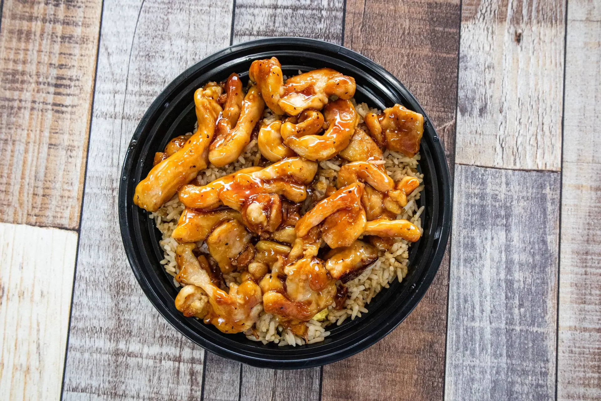 Hibachi chicken over fried rice in a black bowl at Aaron Wings & Hibachi, a Hibachi & Wings Restaurant in Stockbridge