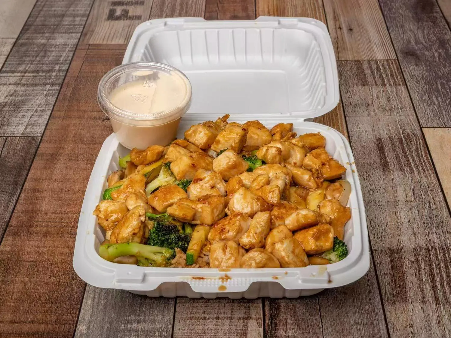 Teriyaki chicken hibachi with broccoli and creamy dipping sauce in takeout box at Aaron Wings & Hibachi, a Hibachi & Wings Restaurant in Stockbridge